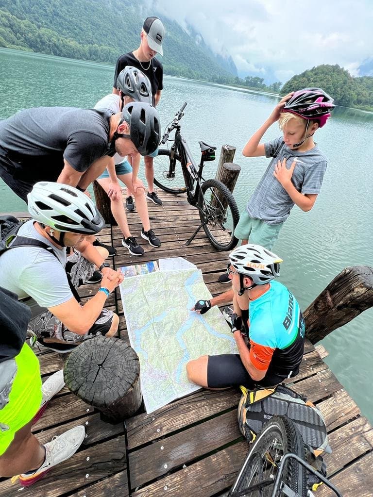 Cyclists Analyzing a Map by the water near Porlezza Cyclists Analyzing a Map by the water near Porlezza